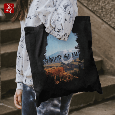 Shikata Ga Nai Mountain Vista Organic Cotton Tote Bag showcasing a mountain landscape with bold typography, eco-friendly and stylish.